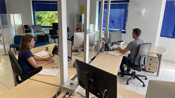 Bureaux partagés ouverts avec deux employés travaillant sur ordinateur