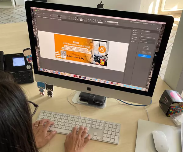 Graphiste travaillant sur une publicité de transport en commun sur iMac